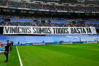 Spectators sit behind a banner reading 'We're all Vinicius' prior to a soccer match in Madrid, Spain.