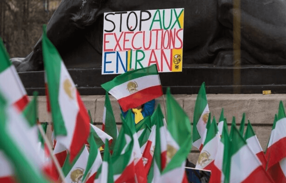 A protester is holding up a sign that reads 'Stop executions in Iran' to protest the visit of Iranian President Hassan Rouhani to France on Thursday, January 28, 2016.