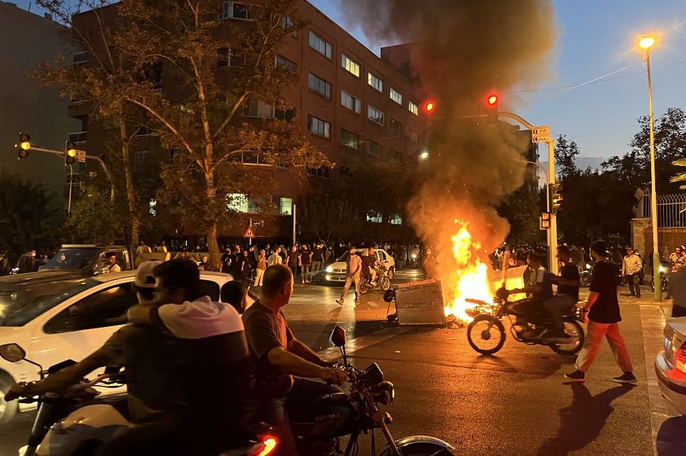 Demonstrators gathering around a burning barricade during a protest for Mahsa Amini, a woman who died after being arrested by the Islamic republic's "morality police," in Tehran, Iran, on September 19, 2022.