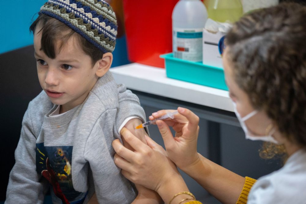 A child receives a dose of the Covid vaccine at a vaccination center in Jerusalem, on December 21, 2021.