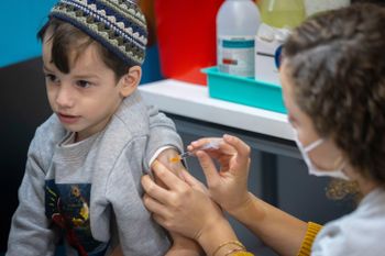 Children receive their dose of the Covid 19 vaccine, at a Clalit vaccination center in Jerusalem on December 21, 2021.
