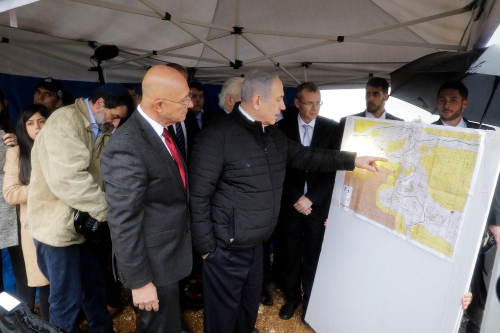 Israel's Prime Minister Benjamin Netanyahu checks an area map during a visit to the Ariel settlement in the West Bank, Monday, Feb. 24, 2020.