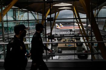 FILE - Iberia jets are seen in a parking zone as police walk through the airport during a Iberia airline workers strike at Barajas international airport in Madrid, Spain
