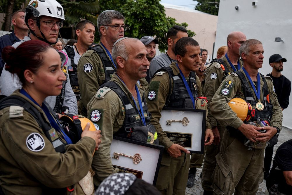 Les membres de l'Unité de sauvetage nationale des Forces de défense israéliennes (FDI), salués avant leur départ le 10 juillet, 2021 à Surfside, Floride