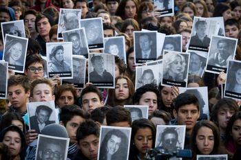 AP Photo/Victor R. Caivano People hold up pictures of the victims from the AMIA Jewish community center bombing on the 21st anniversary of the terror attack in Buenos Aires, Argentina. The bombing of the Argentine-Israeli Mutual Association in downtown Buenos Aires killed 85 people in 1994 and remains unsolved