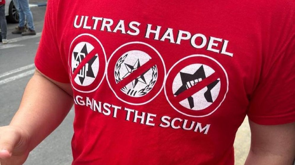 חבר קבוצת האוהדים אולטראס הפועל ת"א עם החולצה עם כיתוב הגנאי