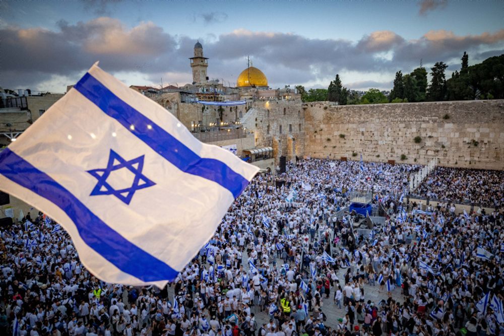 Jews hold Israeli flags as they dance at the Western Wall in Jerusalem's Old City, during Jerusalem Day celebrations.
