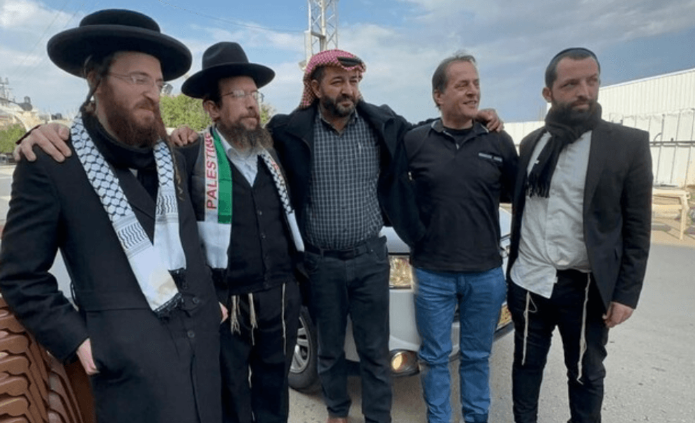 Screenshot used in accordance with Clause 27a of the Copyright Law Members of Neturei Karta with the head of Palestinian Islamic Jihad, Maher al-Akhras (C).