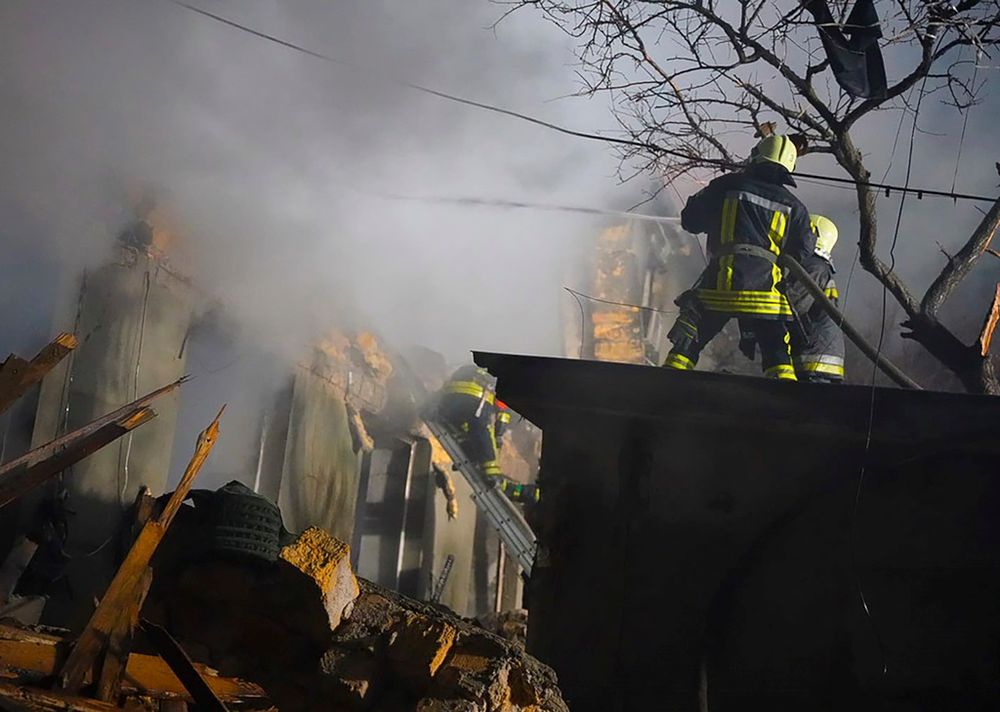 In this photo provided by the Ukrainian Emergency Service, firefighters work on the site of a burning building after a Russian attack in Odesa, Ukraine, Feb. 23, 2024.