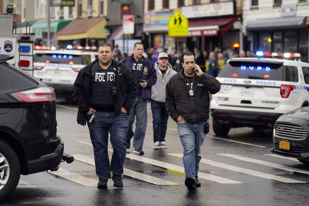 New York City Police Department personnel gather at the entrance to a subway stop in the Brooklyn borough of New York, US, April 12, 2022.