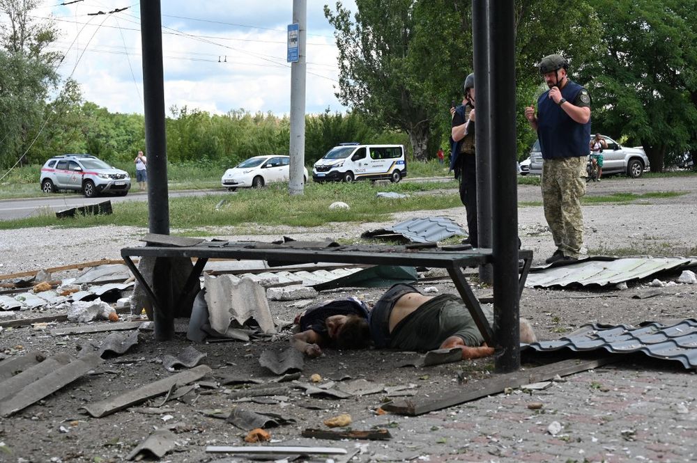 Police experts stand by the bodies of civilians who were killed in a Russian missile strike in Saltivka, a northern district of the Ukrainian city of Kharkiv, on July 20, 2022.