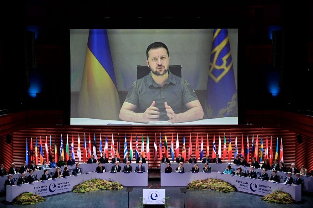 Ukraine's President Volodymyr Zelensky appears on screen to speak at the opening of the 4th Summit of the Heads of State and Government of the Council of Europe, at the Harpa concert hall in Reykjavik, Iceland