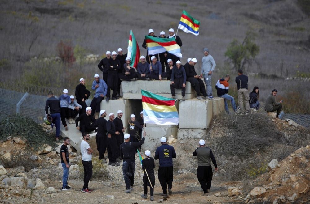 Members of the Druze community gather around their flag