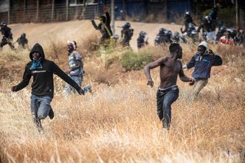 Migrants run on Spanish soil after crossing the fences separating the Spanish enclave of Melilla from Morocco in Melilla, Spain, on June 24, 2022.