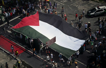 Des militants brandissent un immense drapeau palestinien lors de la « Grande Marche du Peuple » organisée en marge de la COP30, la conférence des Nations Unies sur les changements climatiques à Belém, dans l'État du Pará, au Brésil, le 15 novembre 2025. 