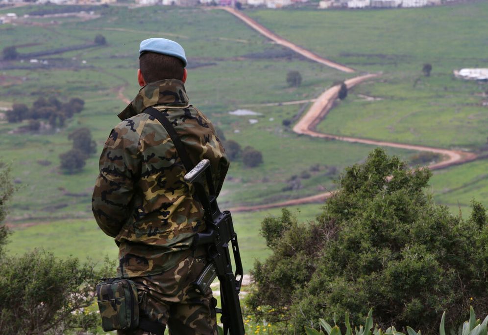 A UN peacekeeper looks to the United Nations-demarcated 'Blue Line' border between Lebanon and Israel, in the disputed Chebaa farms area of southeast Lebanon, on February 24, 2015.