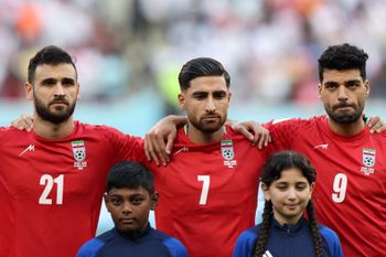 Iran's midfielder #21 Ahmad Noorollahi, Iran's midfielder #07 Alireza Jahanbakhsh and Iran's forward #09 Mehdi Taremi listens to the national anthem ahead of the Qatar 2022 World Cup Group B football match between England and Iran at the Khalifa International Stadium in Doha on November 21, 2022.