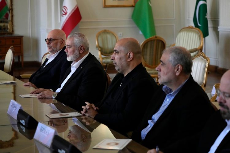 Hamas chief Ismail Haniyeh, second left, and his delegation listen to Iranian Foreign Minister Hossein Amirabdollahian during their meeting in Tehran, Iran.