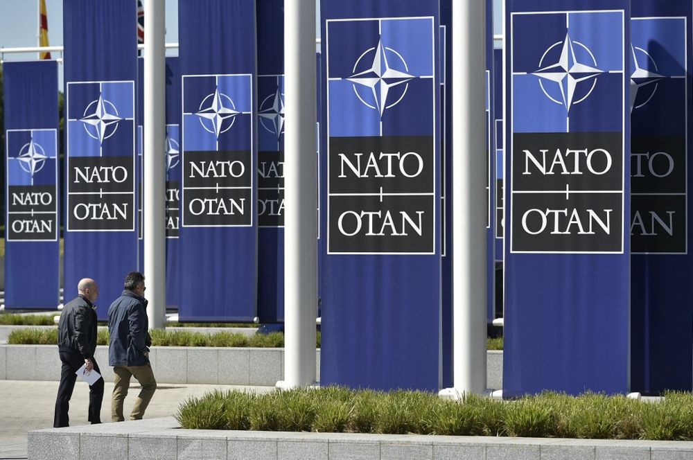 Two men arrive at the entrance of the new building housing the NATO headquarters in Brussels, Belgium, on May 7, 2018.