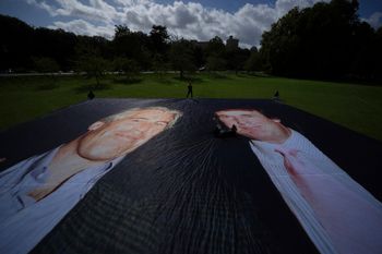 Activist from the protest group Everyone Hates Elon put up a poster of President Donald Trump and Jeffrey Epstein, ahead of the state visit by U.S. President Donald Trump, in Windsor, England, Monday, Sept. 15, 2025. 