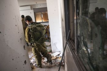 Des soldats israéliens observent des destructions causées par les terroristes du Hamas dans le kibboutz Nir Oz le 7 octobre 2023