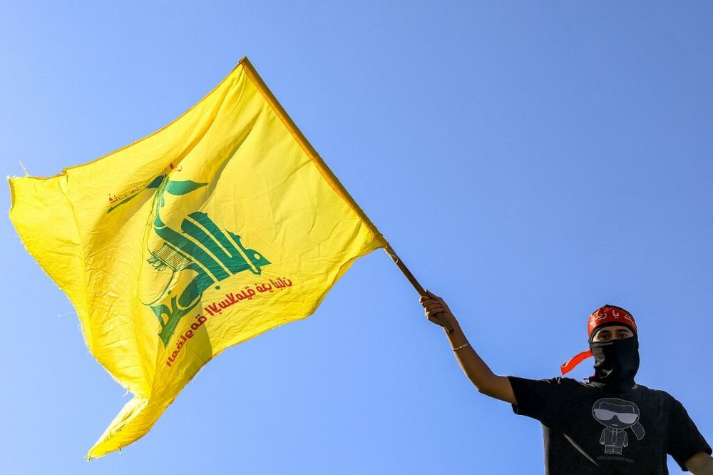 Un manifestant masqué brandit un drapeau du Hezbollah lors d'une manifestation de soutien aux Palestiniens à Beyrouth, le 20 octobre 2023