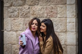 Two women pose for a selfie in central Jerusalem.