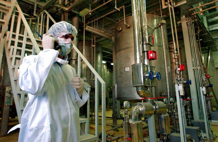 FILE - Wearing protective clothes, an Iranian security person visits a part of the Uranim Conversion Facility, just outside the city of Isfahan, Iran.