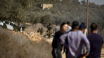 File photo showing IDF soldiers and Israeli settlers in the West Bank village of Qusra
