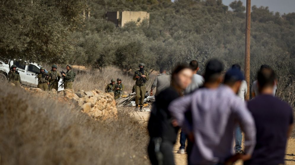 File photo showing IDF soldiers and Israeli settlers in the West Bank village of Qusra