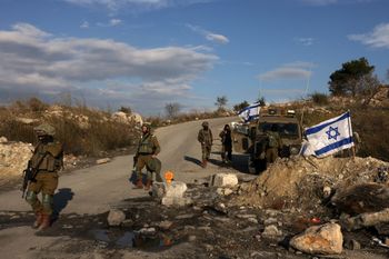 Israeli soldiers guard a road at the Homesh outpost, west of the West Bank city of Nablus, on December 30, 2021.