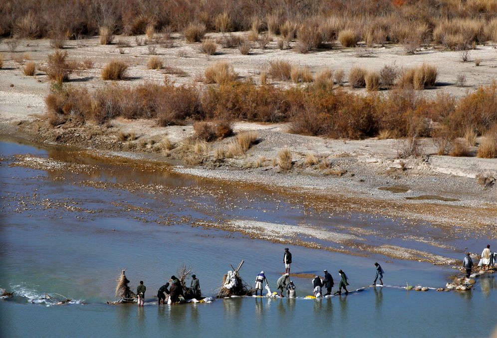 Afghans try to repair a dam on a river in southern Afghanistan.