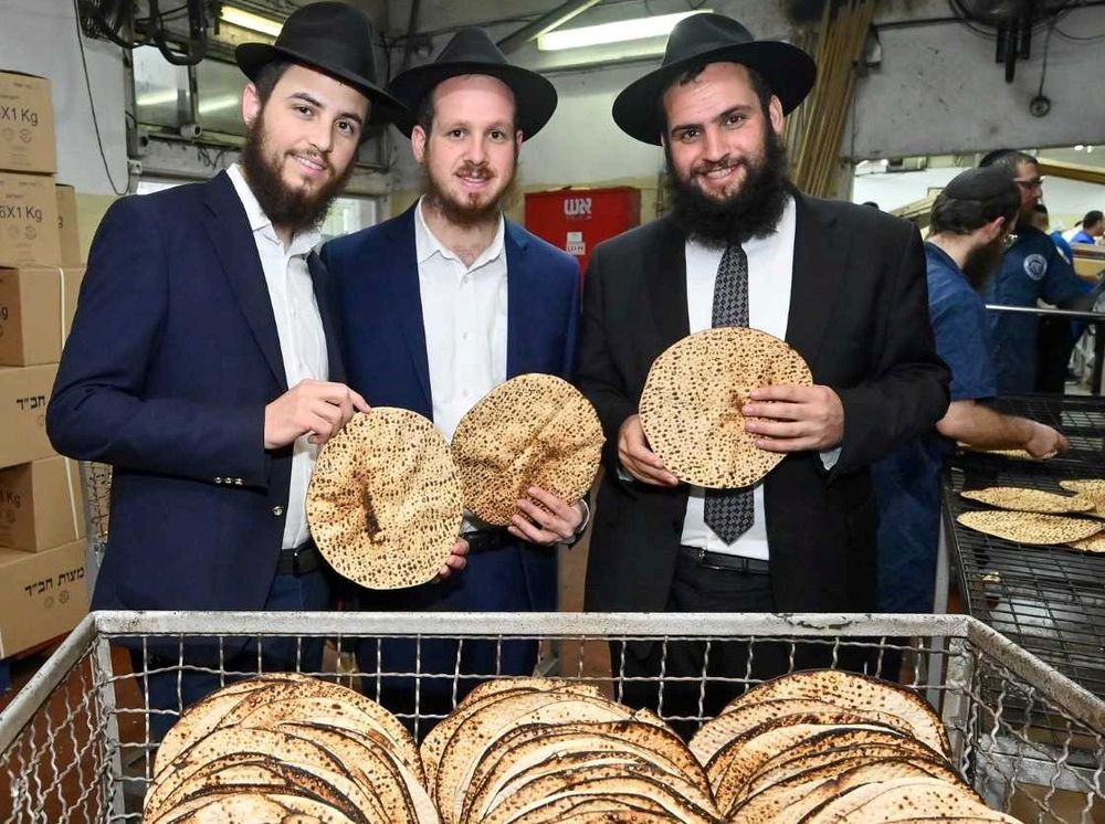 Rabbi to the UAE Rabbi Levi Duchman (R), together with the Dubai community Rabbis, Rabbi Mendel Blau and Rabbi Mendel Duchman, pose with matzah in Kfar Chabad, Israel, on March 21, 2022.