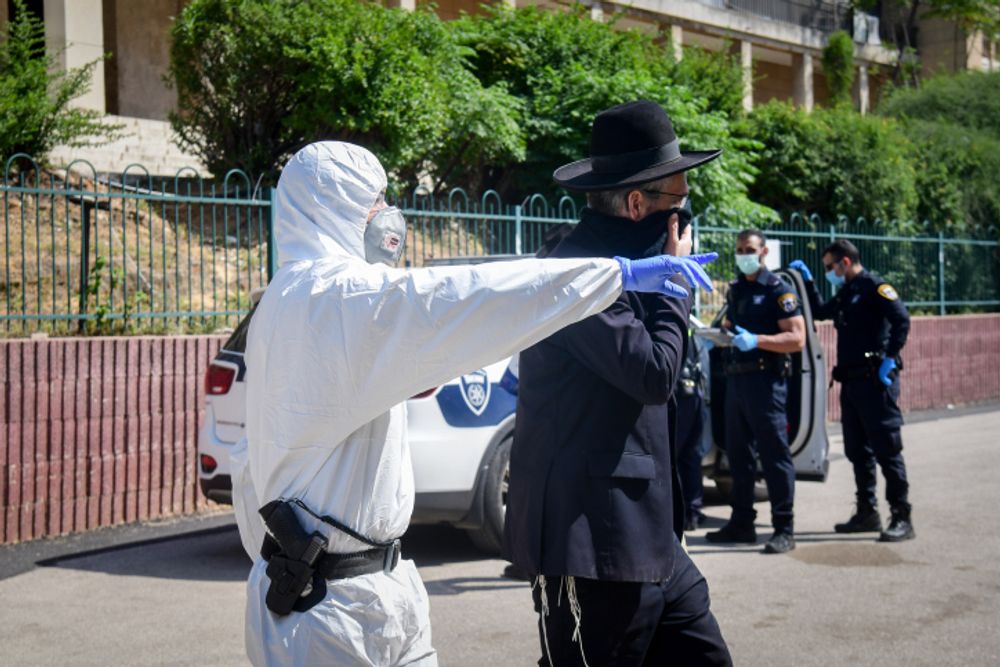 Des policiers israéliens expulsent des juifs ultra-orthodoxes de la Yeshiva de Ponevezh à Bnei Brak, dans le cadre des restrictions visant à empêcher la propagation du coronavirus, le 2 avril 2020.