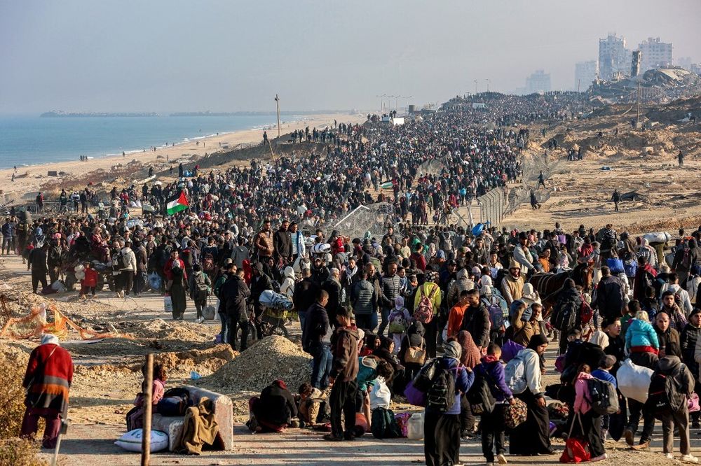 Des Palestiniens marchent le long de la rue côtière Al-Rashid à Gaza pour traverser le corridor de Netzarim depuis le sud de la bande de Gaza vers le nord, le 27 janvier 2025