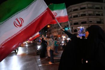 Women hold Iranian flags for a pro-government campaign in downtown Tehran, Iran, Friday, May 8, 2026. 