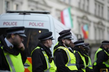 Police stand guard during a protest outside the Iranian Embassy in London, Monday, Jan. 12, 2026. 