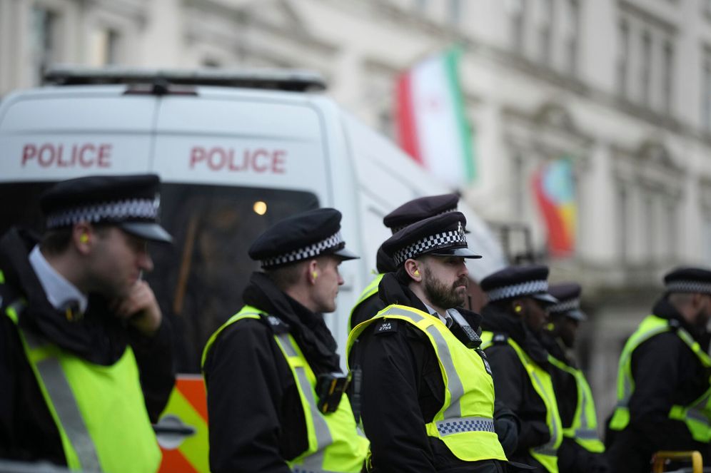 Police stand guard during a protest outside the Iranian Embassy in London, Monday, Jan. 12, 2026. 