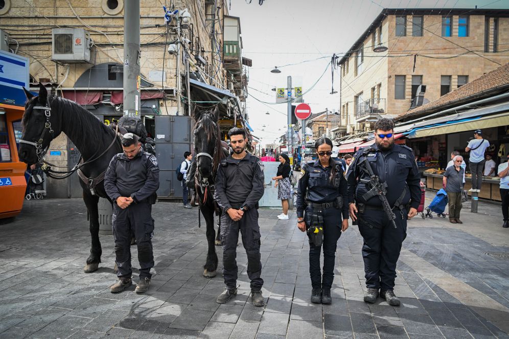 Les forces de sécurité se tiennent debout pendant la sirène en mémoire des victimes de la Shoah à Mahane Yehuda, Jérusalem, le 24.04.2025