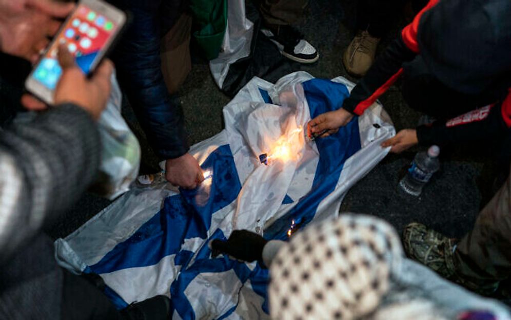 Des manifestants pro-palestiniens brûlent un drapeau israélien lors d'une marche, le 10 novembre 2023, à New York