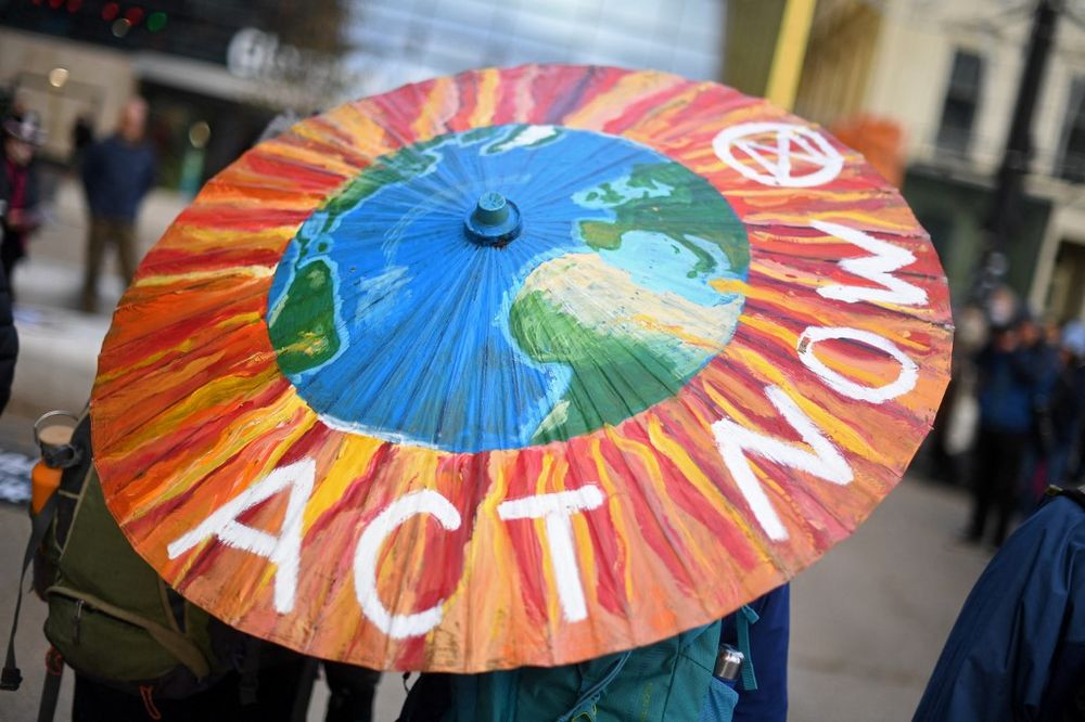 A protester holds a painted parasol in George Square ahead of a protest by Climate activist group Extinction Rebellion in Glasgow, Scotland, on November 7, 2021.