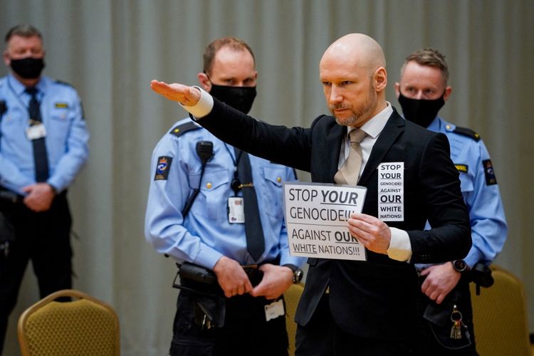 Anders Behring Breivik raises his arm to make a Nazi salute as he arrives on the first day of the trial where he is requesting release on parole, on January 18, 2022 at a makeshift courtroom in Skien prison, Norway.