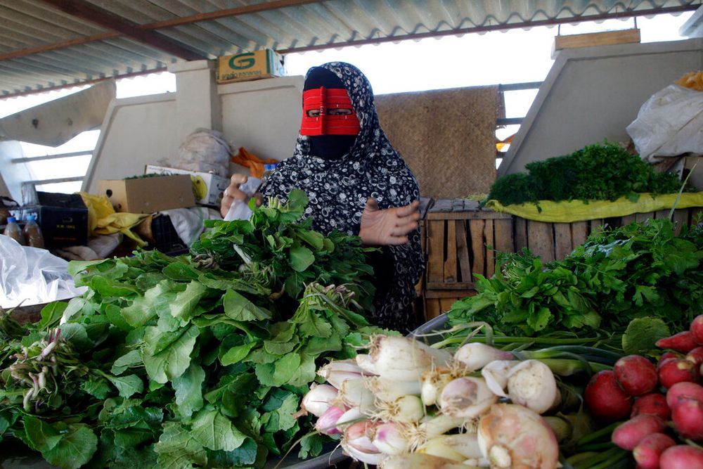 A vendor works at her produce shop on the island of Qeshm, which oversees the strategic waterway of the Strait of Hormuz, Iran.