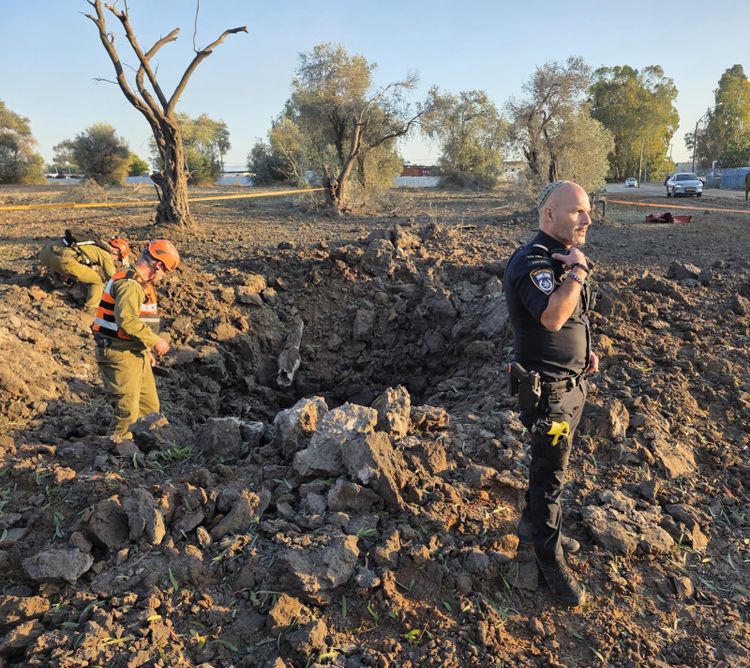 Central District Police and Border Guard soldiers handle scenes of fallen Hezbollah missile shrapnel