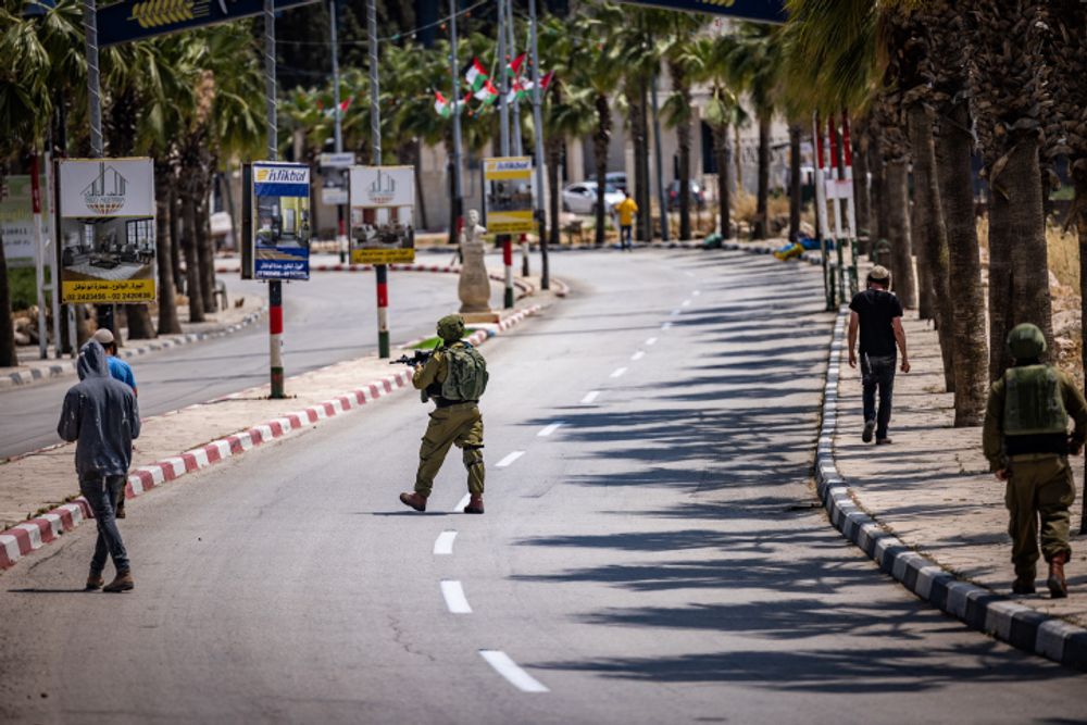 Israeli security forces argue with Jewish settlers at the entrance to the West Bank village of Turmus Aya.