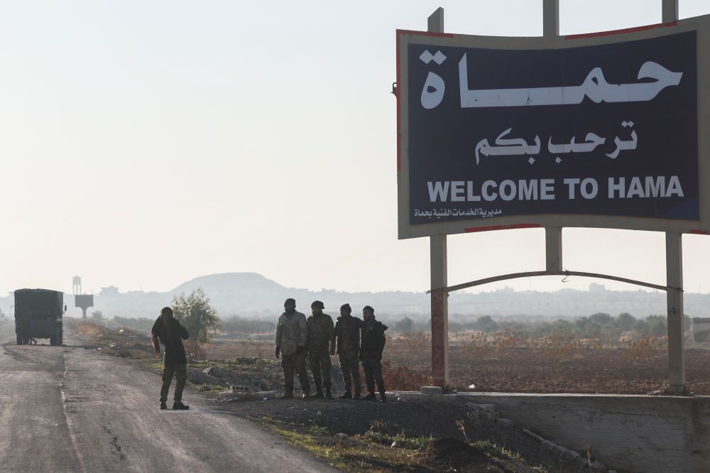 Syrian opposition fighters take pictures in the outskirts of Hama, Syria  