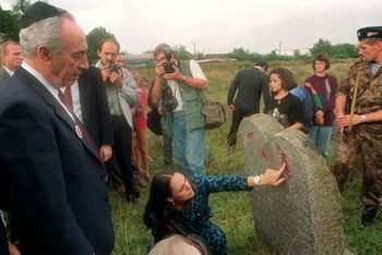 Shimon Peres devant la tombe de son arrière-grand-père dans un cimetière juif abandonné de la ville de Volozhin, en Biélorussie, le 23 août 1992, à l'occasion de sa première visite dans le pays depuis son enfance