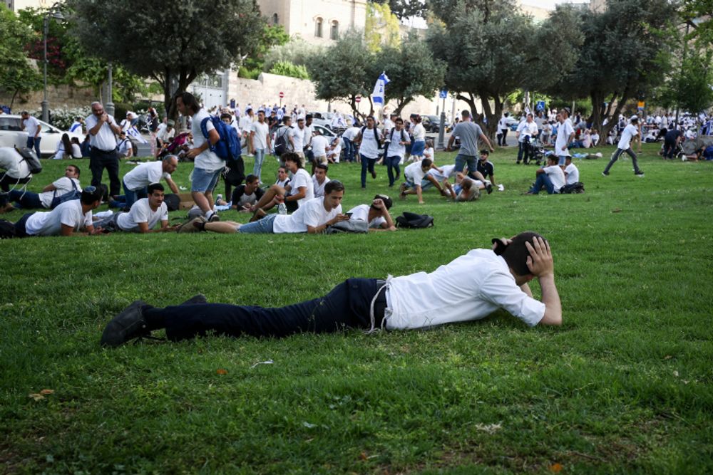 Israelis take cover as a siren sounds warning of incoming rockets from the Gaza Strip, in Jerusalem, Israel, on May 10, 2021.