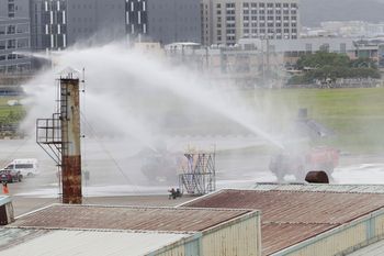 Two fire trucks spray water during the annual Han Kuang military exercises that simulates an attack on an airfield at Taoyuan International Airport in Taoyuan, northern Taiwan.
