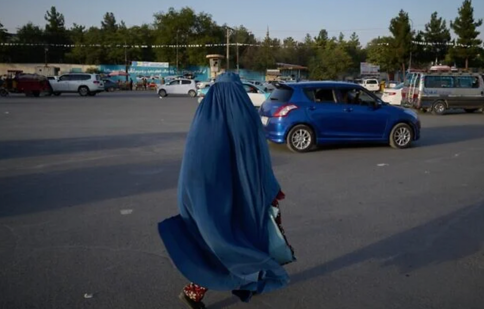 Une femme portant une burqa marche dans une rue, à la veille du cinquième anniversaire du retrait américain et du retour au pouvoir des Talibans, à Kaboul, en Afghanistan, le 14 août 2026.